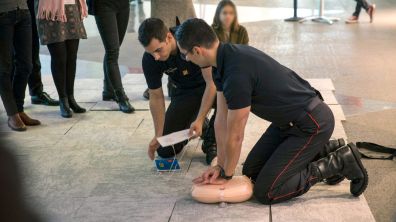 Présence de deux sapeurs-pompiers montrant un exercice pour pratiquer le massage cardiaque
