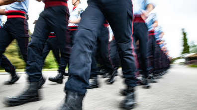 Sapeurs-pompiers en rang en train de défiler en tenue de cérémonie