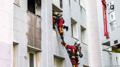 Binôme de sapeurs-pompiers de Paris pénétrant dans un appartement en passant par la fenêtre