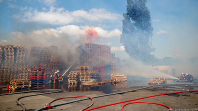 Binôme de sapeurs-pompiers de Paris, lance grande puissance en main, sur un feu de palettes